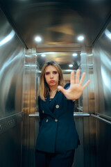 Woman in an Elevator Making Halt Hand Gesture Saying Stop. Boss rejecting someone making a warning frustrated non verbal sign