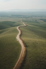 Winding dirt road through green hills