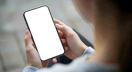 Person holding a modern smartphone with a blank white screen in an indoor setting