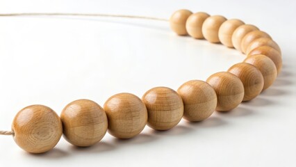 Perfectly smooth polished wooden beads are carefully strung in a precise alignment on a white background, showcasing natural material and craftsmanship.