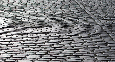 Cobblestone texture. Stone pattern background. Vintage cobblestone surface. Shiny cobblestone surface pattern. Historic stone cobblestone texture. Urban detail.
