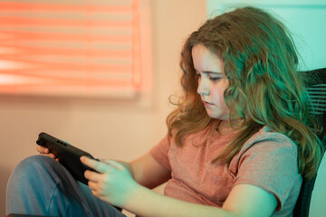 Child playing video game with joystick. Child using game controller playing video console game. Teenager using game controller at home. Kid playing online computer games. Video gaming.
