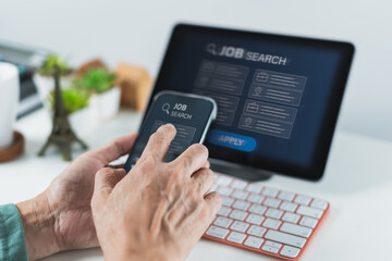 Hands Using Mobile Phone for Job Search While Tablet Displays Job Listings and Apply Interface