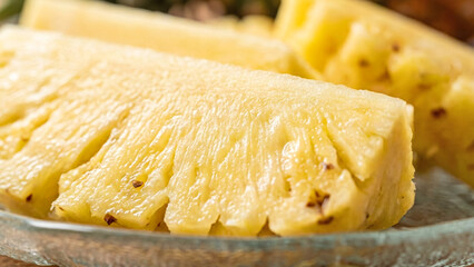 Ripe pineapple fruit pieces on transparent plate with natural lighting. High-quality stock image for grocery, nutrition, and tropical lifestyle.