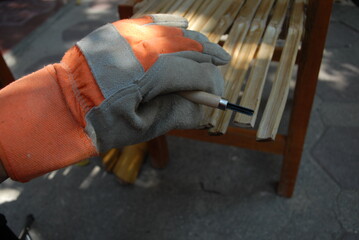 Artisanal process of covering door windows with natural bamboo sticks using basic hand tools and safety gloves