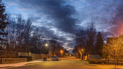Cityscape with  with street road night lights on and dark cloud in sky