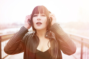 Girl in headphones listening to music outdoors