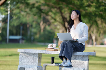Young woman enjoying remote work studying outdoors