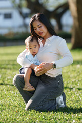 Mother putting shoe on happy baby outdoors