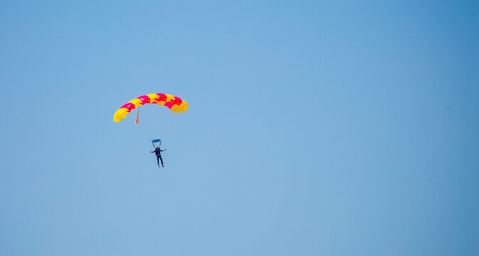 Skydiving. Flying parachutists against the background of the blue sky and mountains. Extreme sport and entertainment.