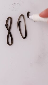 A person writes 70 percent on a white board, then erases it with a cloth. Next, the person writes 80 percent on the same white board for a special offer.