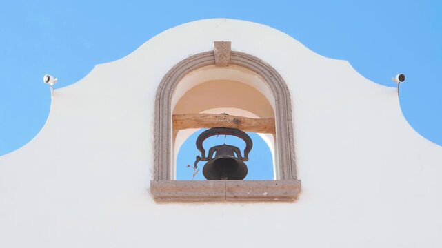 Traditional heavy vintage bell ringing in white building. Bell tower.