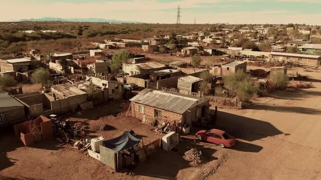 Drone, poor Mexican neighborhood with barebone houses. Aerial view Poor living conditions streets and rusty metal home roof tops. Shack, village in a ghetto or slum.