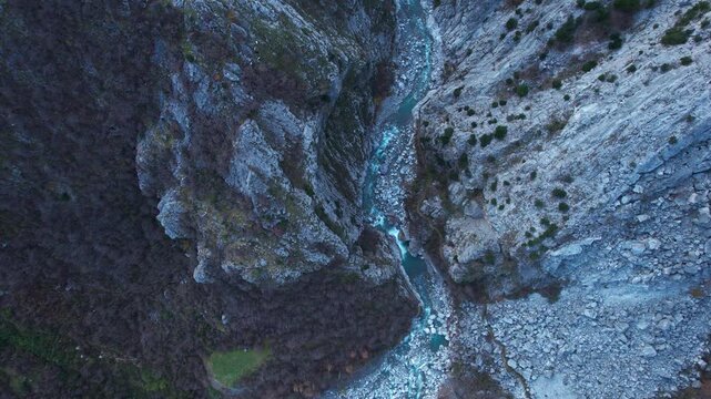 Deep Rocky Gorge with Pure Emerald River Streaming Over Rocks in Scenic Northern Albanian Mountains
