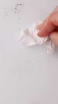 A hand writes different discount percentages on a clean surface. Each percentage is wiped away, showing new savings. This demonstrates changing offers and promotions for a sale.