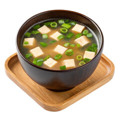 Miso soup with tofu and green onions in a dark bowl on a wooden tray isolated on white background