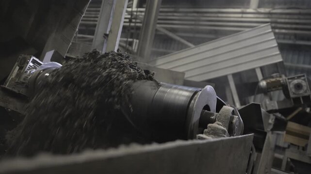Grooved steel roller redistributes crushed rubber in controlled motion. Tire recycling system relies on durable mechanical components