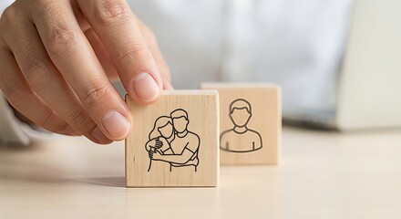 Business hand moving wooden cube with hugging couple icon next to single person block, symbolic of family protection planning, life insurance, building healthy social relationships and marriage counse