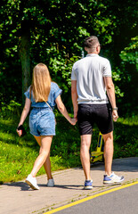 Obraz premium A man and a woman walk in a summer park 