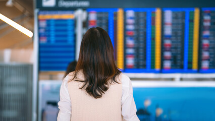 Standing passenger looking flight information status board at international airport terminal © dodotone