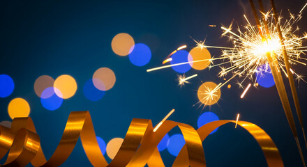 Festive sparkler with golden ribbon on blurred light background, representing celebration, joy, and special occasion like New Year's or anniversary