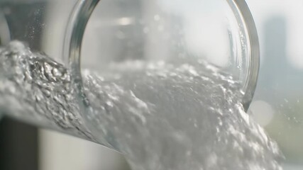 Clear liquid pouring from a glass beaker in a laboratory setting. - Powered by Adobe