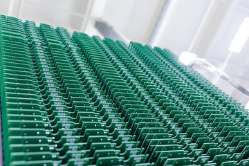 Fototapeta premium Rows of green printed circuit boards in electronics manufacturing plant