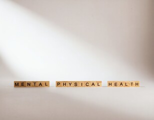 A minimalist composition featuring wooden blocks with the words 'MENTAL', 'PHYSICAL', and 'HEALTH' arranged horizontally on a plain surface with soft, natural lighting.