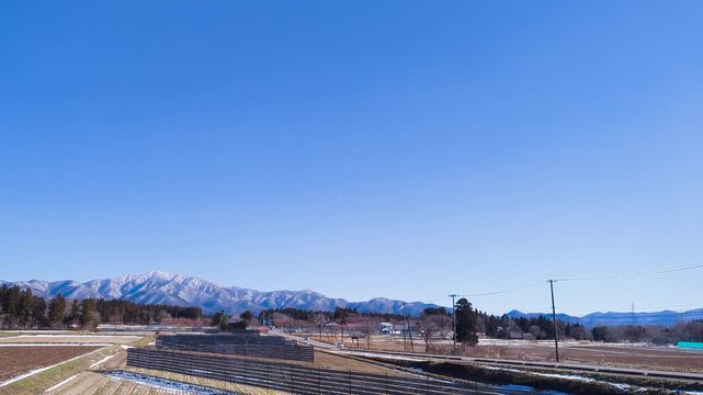 青空の下に広がる冠雪したばかりの初冬の磐梯山とネコママウンテンスキー場