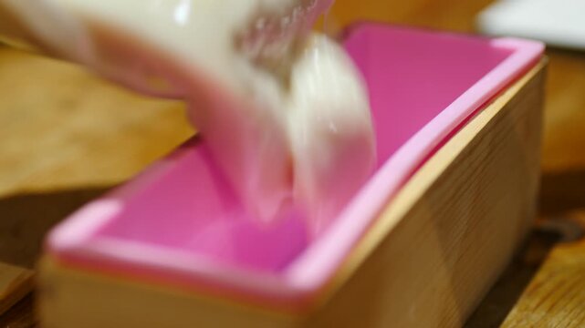 Pouring coconut soap into mold at thick trace