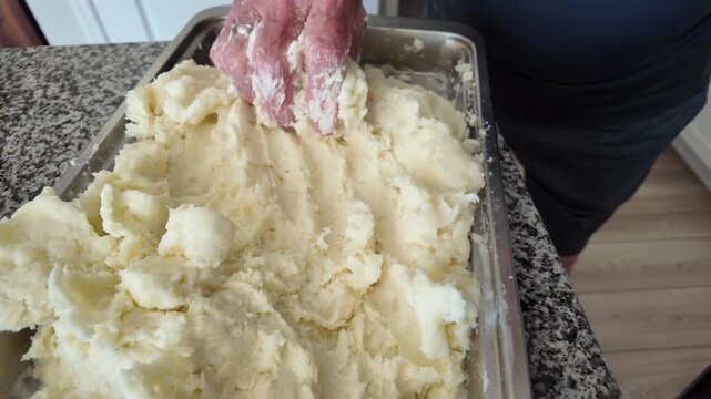senior hands work to knead yucca paste, a South American starch staple