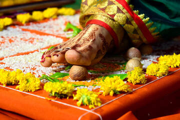 Close-up of bride’s decorated foot with mehndi and toe ring during traditional Hindu wedding ritual, symbolizing auspicious beginning, marriage customs, and Indian culture.
