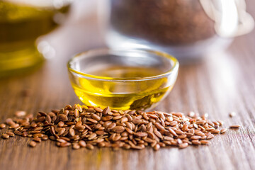 Brown linseed or flaxseed and oil. Healthy flax seed on wooden table.
