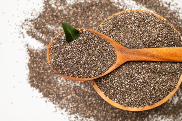 Chia seeds in wooden spoon and bowl on white background, top view. Organic, healthy seeds for digestion, source of omega-3 and protein. Superfood. Food background