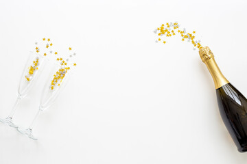 Christmas decoration flat lay with champagne bottle and two glasses, top view