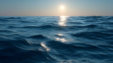 Obraz premium The sun rises over a calm ocean casting a shimmering golden reflection across the gentle blue waves towards the horizon
