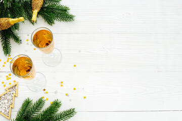 Christmas decoration top view - fir tree branch and two glasses of champagne. Festive flat table setting