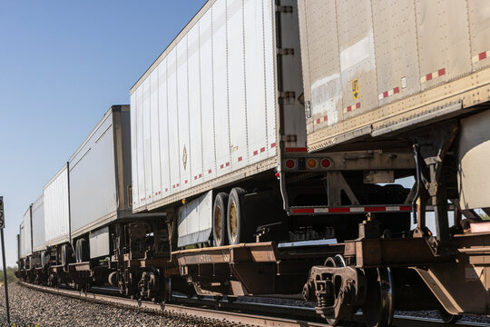 Truck trailers on train cars on train tracks