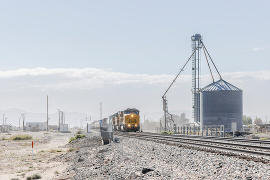 Dusty rural farming landscape with approaching train