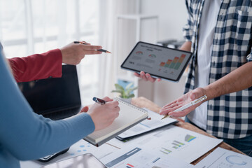 Business team analyzing financial data on tablet and documents