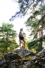Obraz premium Woman hiking in forest looking to sky achieving success