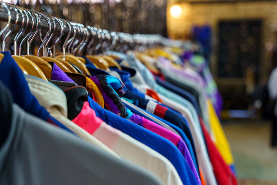 Assorted Vintage and Second Hand Clothing on Hangers in a Thrift Store