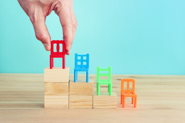 Small plastic chairs on wooden steps. Idea ofpersonal growth and development