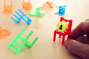 hand places a red chair with a figure. Idea of leadership or human resources