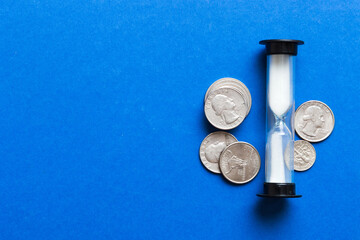 Deadline and time is money concept with hourglass and US coins currency. sand clock time for saving concept