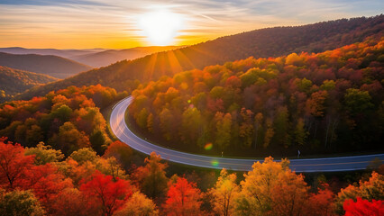 Obraz premium Winding mountain road through vibrant autumn forest at sunset fall trees