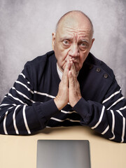 portrait homme &acirc;g&eacute; devant son simple bureau
