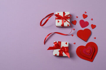 Valentine's Day banner with gift boxes surrounded by red hearts on a colorful background. Perfect for romantic and festive events.

