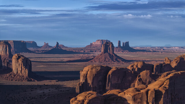 Aerial view of the majestic Monument Valley's sandstone buttes glowing under the serene sky, creating a tapestry of warm and cool hues., Oljato-Monument Valley, Arizona, United States.