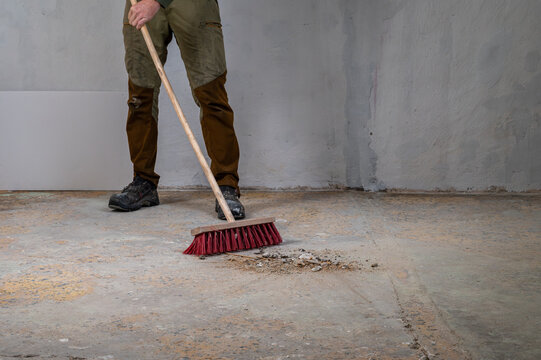 Worker sweeping debris during renovation